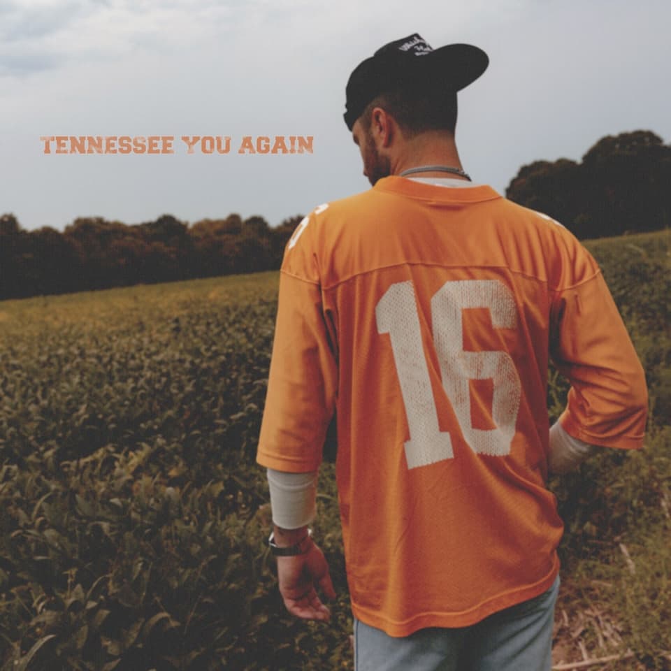 Tennessee You Again cover art: Greylan James from behind in an orange number 16 football jersey and black cap, walking through a field under an overcast sky